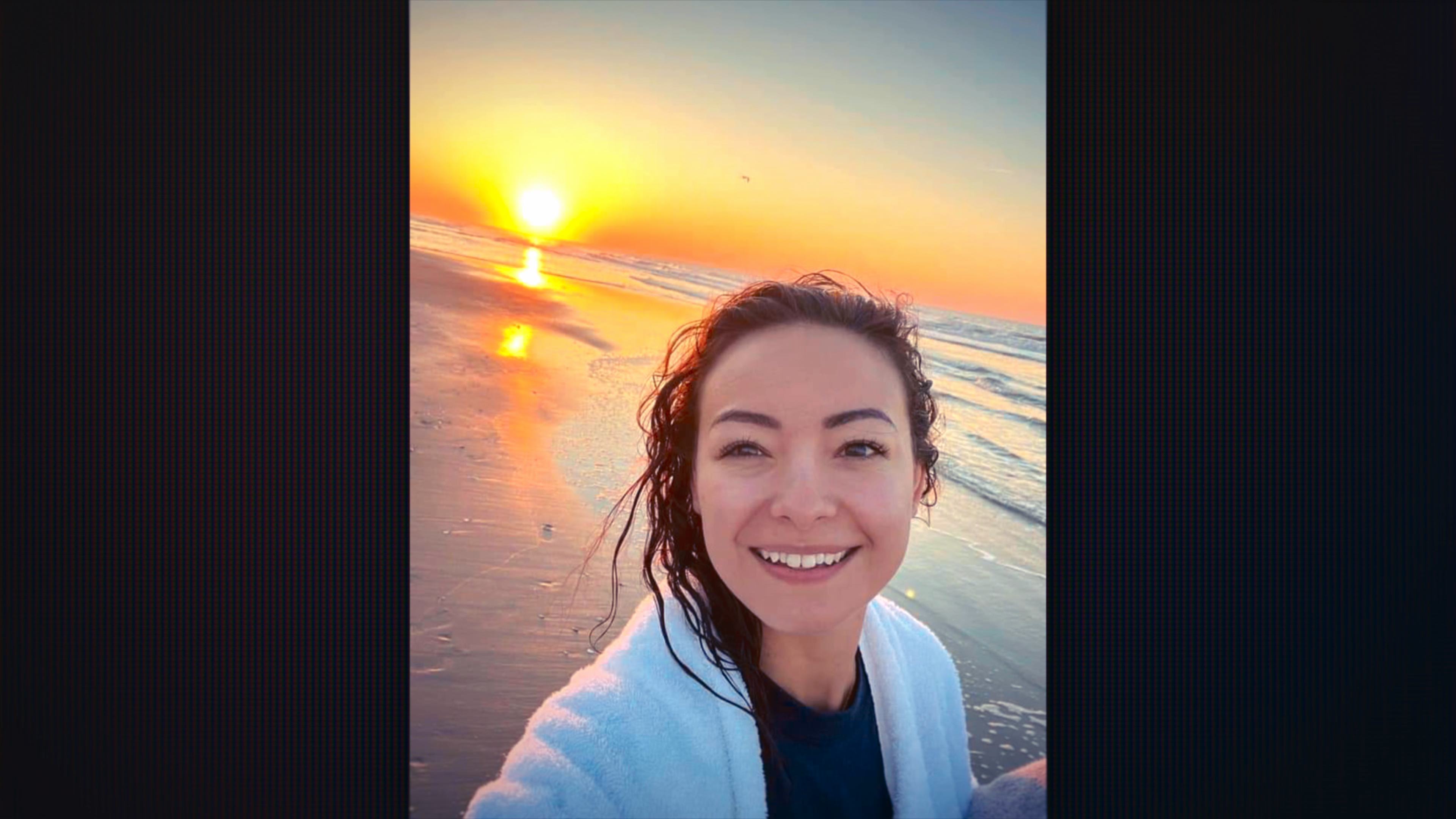 &Quot;Smiling Woman Taking A Selfie On A Beach At Sunrise, Wearing A White Towel, With Wet Hair, The Sun Low Over The Ocean, And Waves Gently Rolling Onto The Shore Under A Colorful Sky.&Quot;