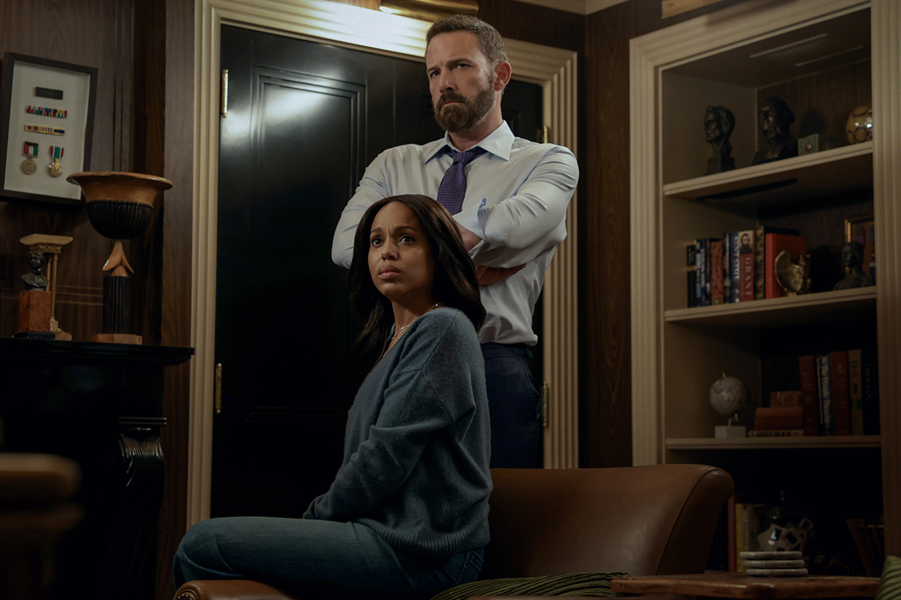 &Quot;A Woman Sits On A Leather Chair Looking Concerned, While A Man Stands Behind Her With Arms Crossed In A Dimly Lit Office Or Library Filled With Shelves, Books, And Decorative Objects.&Quot;