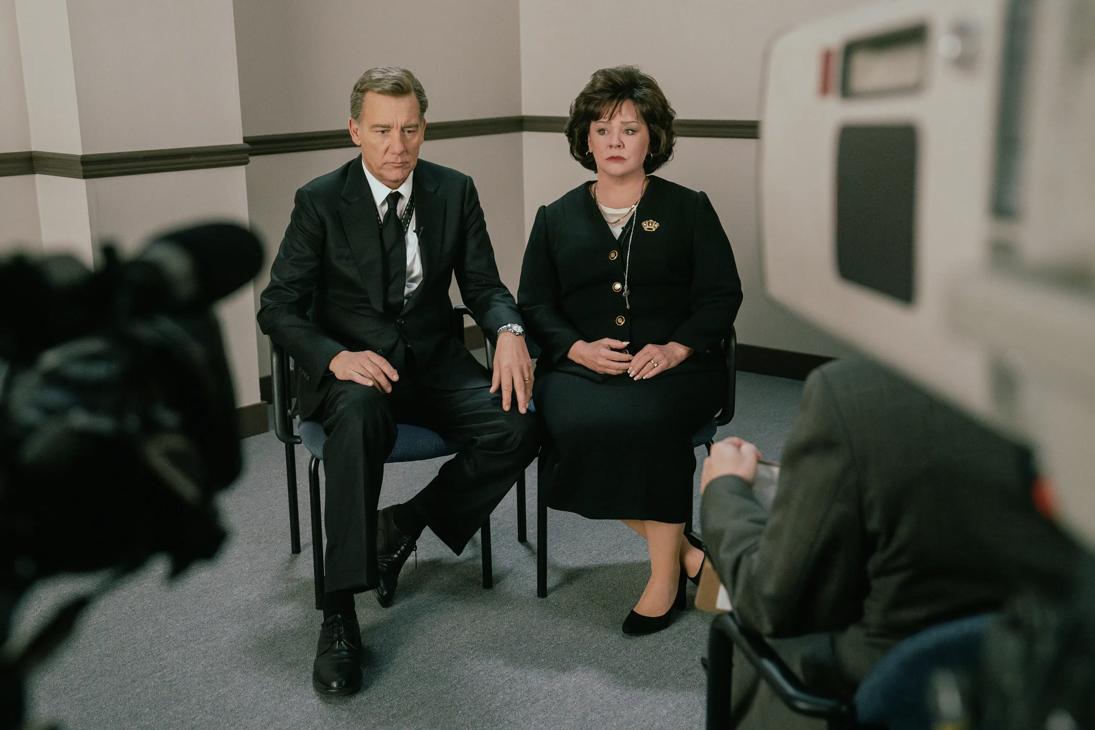Clive Owen Melissa Mccarthy The Murder Of Jonbenet Ramsey &Quot;Two People In Formal Attire Sit Side By Side In A Plain Office-Like Room, Holding Hands, Being Filmed By A Video Camera During An Interview Or Press Conference.&Quot;