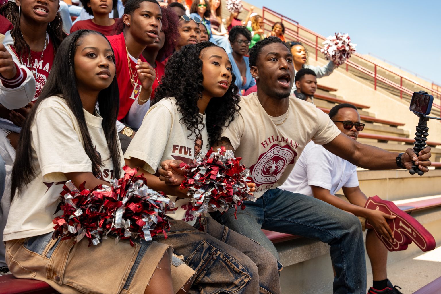 &Quot;A Group Of Enthusiastic Fans In Matching Shirts Sit In Stadium Bleachers, Holding Pom-Poms And Cheering During A Sporting Event On A Sunny Day.&Quot;